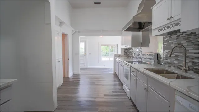 a kitchen with granite countertop white cabinets and white appliances
