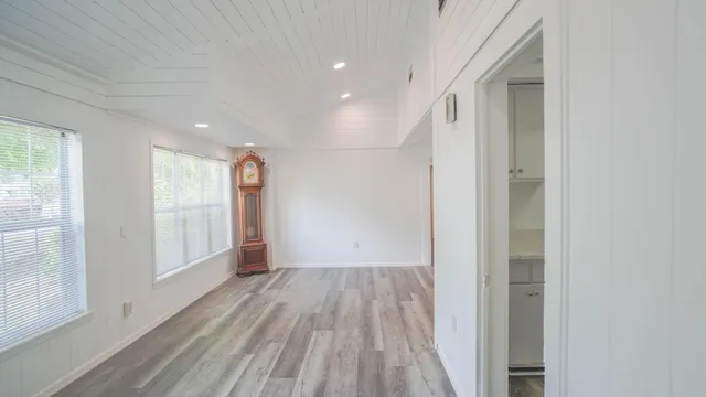 a view of empty room with wooden floor and window