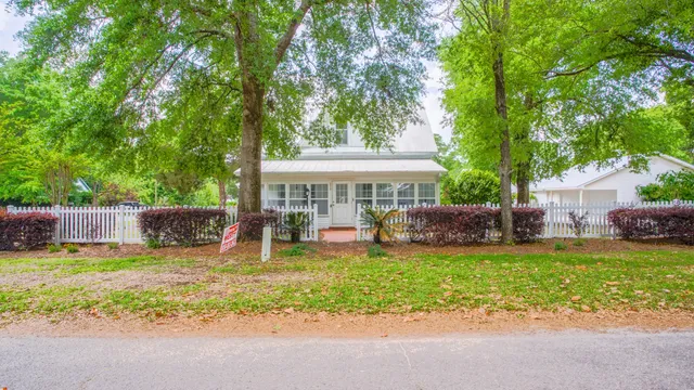 a view of a house with a yard and palm trees