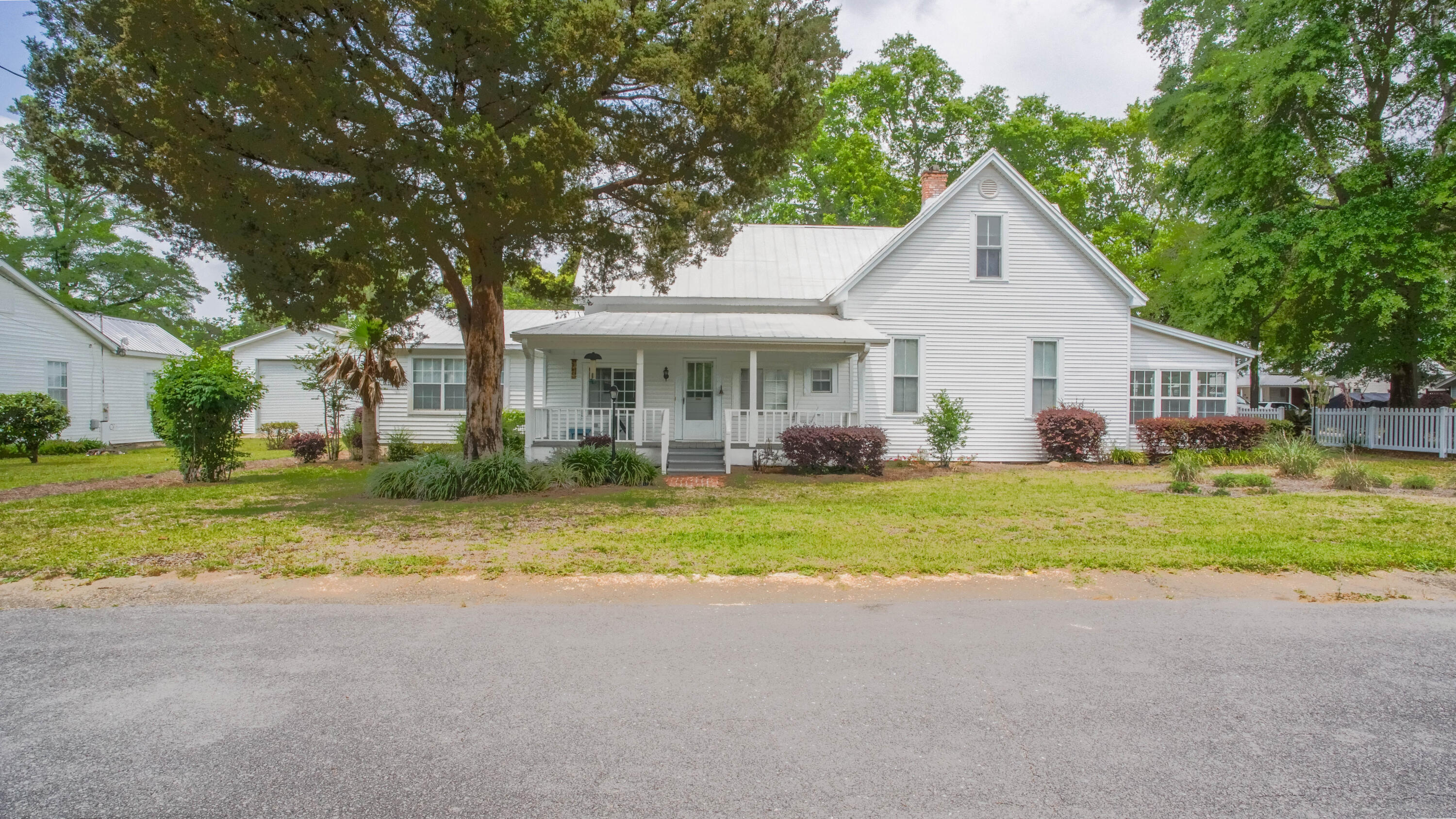 270 South 12th Street DeFuniak Springs, FL 32435 - Photo 4 of 57 a view of a house with a yard and palm trees