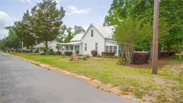 a view of a house with a yard and tree s