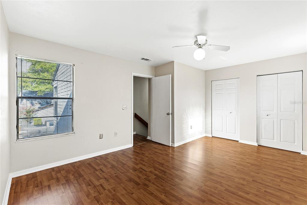 4345 Southwest 20th Lane Gainesville, FL 32607 - Photo 14 of 17 an empty room with wooden floor chandelier fan and windows
