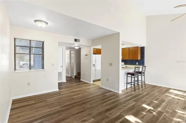 a view of a livingroom with wooden floor and a flat screen tv