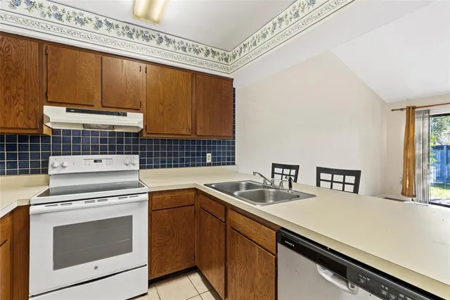 a kitchen with stainless steel appliances a stove a sink and a microwave