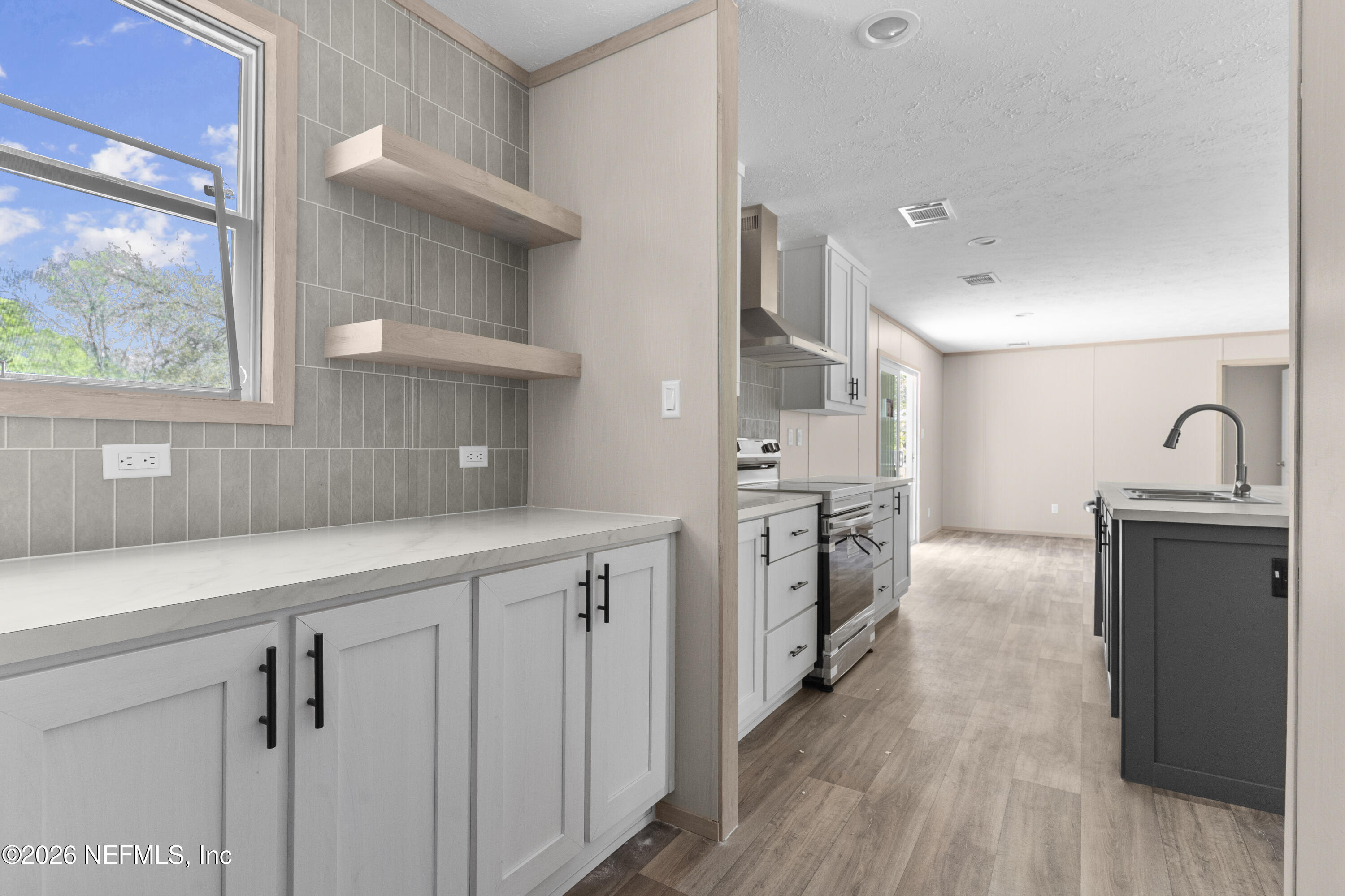 10101 Co Road Sanderson, FL 32087 - Photo 7 of 10 a kitchen with cabinets and wooden floor