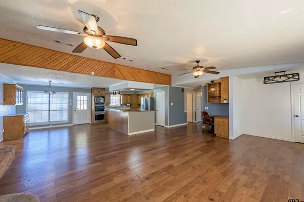 a view of a room with wooden floor and chandelier