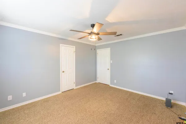 an empty room with windows and fan