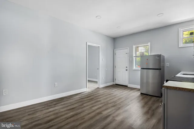 a view of a kitchen with wooden floor and electronic appliances