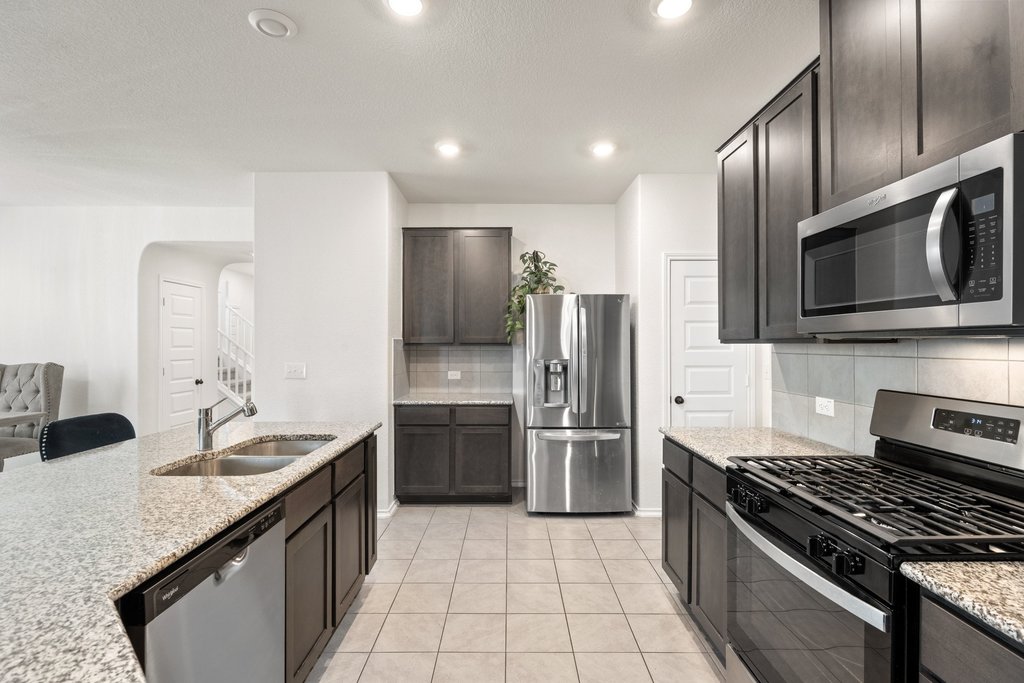 218 Summit Drive Lockhart, TX 78644 - Photo 13 of 38 a kitchen with granite countertop a sink and stainless steel appliances
