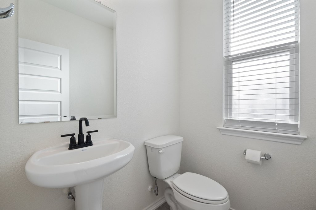 218 Summit Drive Lockhart, TX 78644 - Photo 19 of 38 a bathroom with a sink a mirror a toilet and a window