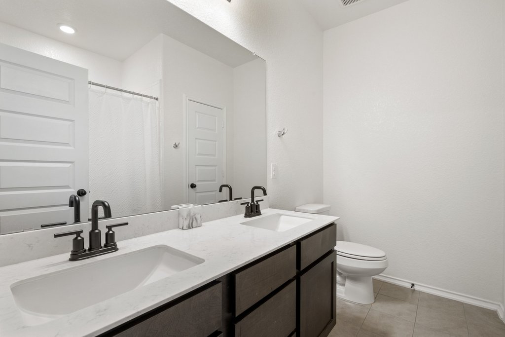 218 Summit Drive Lockhart, TX 78644 - Photo 23 of 38 a bathroom with a sink a toilet and mirror