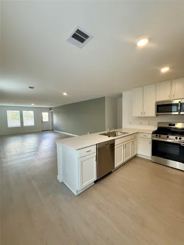 a kitchen with stainless steel appliances a white stove top oven and a sink with granite countertops