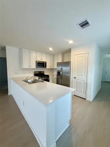 a kitchen with stainless steel appliances granite countertop a refrigerator sink and cabinets