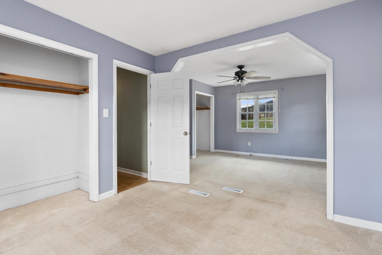 1052 Dutch Hollow Road Raphine, VA 24472 - Photo 11 of 46 an empty room with windows and a ceiling fan