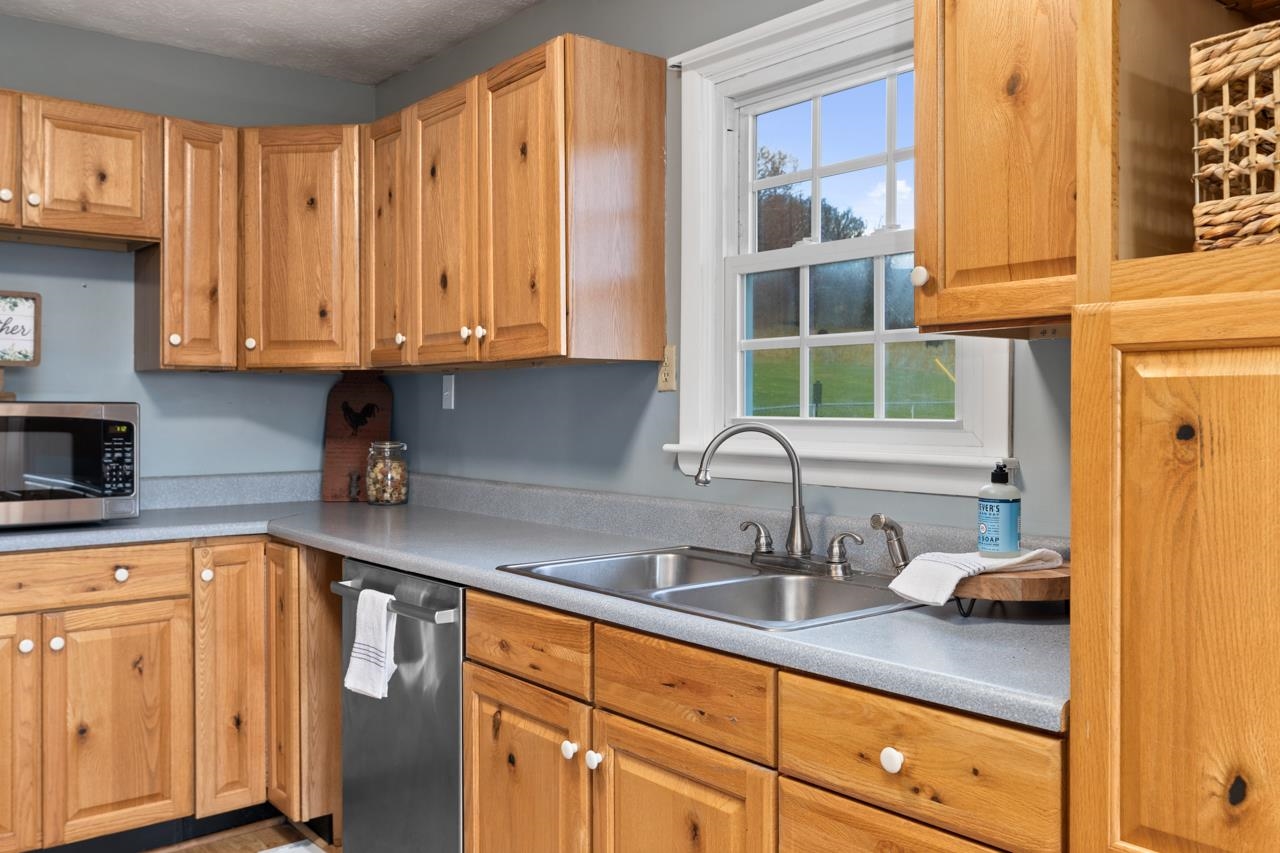 1052 Dutch Hollow Road Raphine, VA 24472 - Photo 3 of 46 a kitchen with stainless steel appliances granite countertop white cabinets a sink and dishwasher with wooden floor