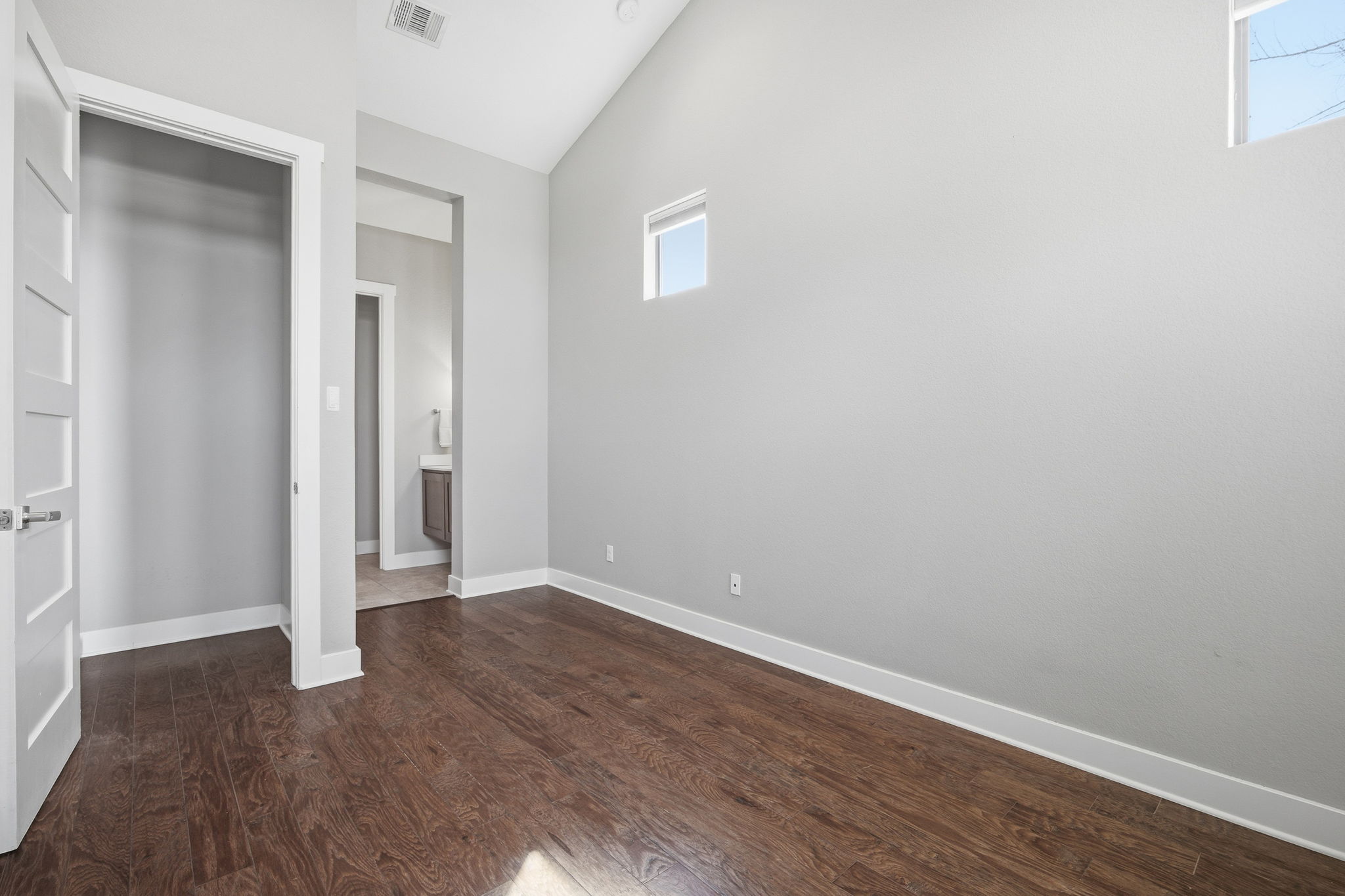 3521 Marcae Court Austin, TX 78704 - Photo 24 of 37 Unfurnished bedroom with ensuite bathroom, dark wood-style flooring, and vaulted ceiling