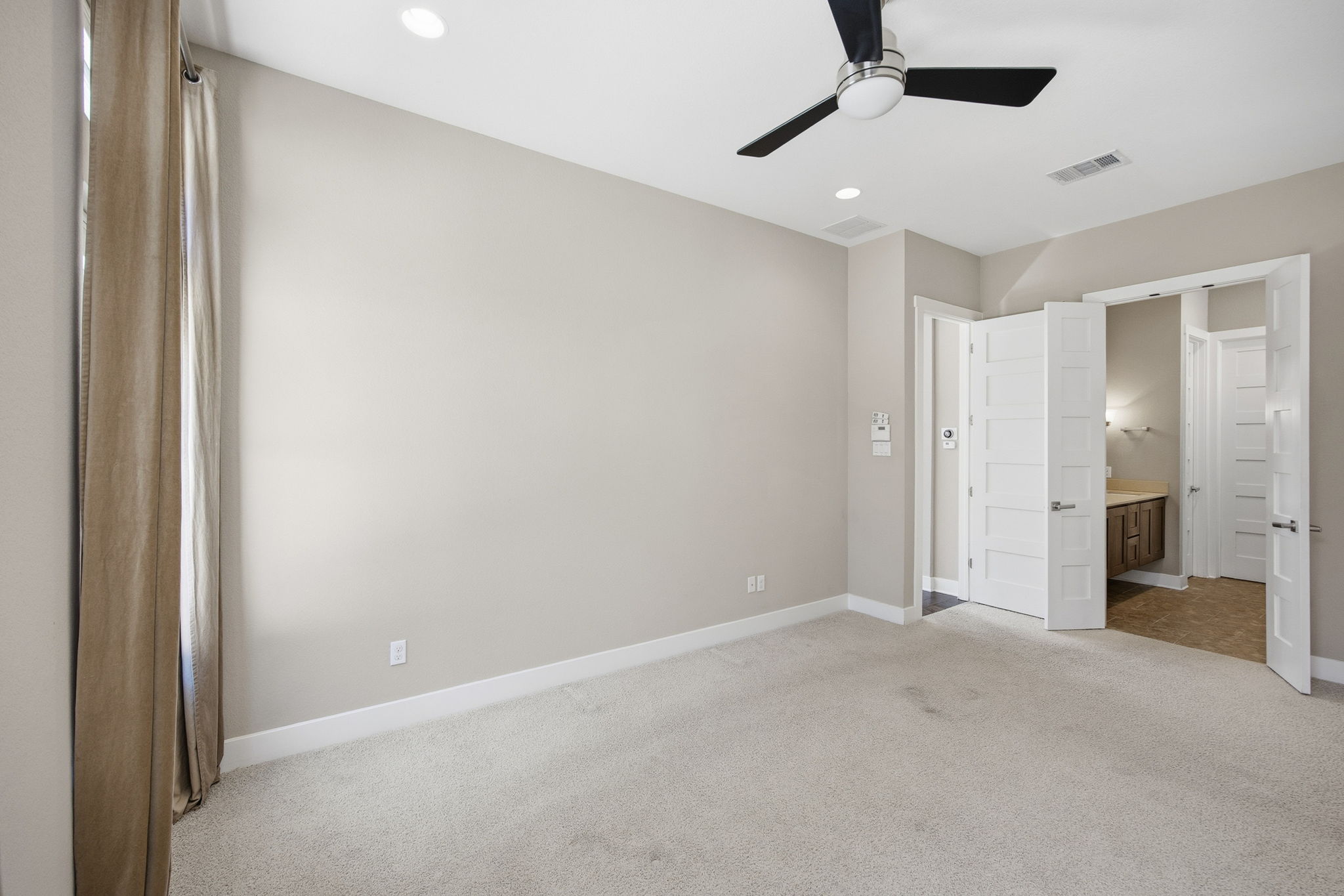 3521 Marcae Court Austin, TX 78704 - Photo 27 of 37 Unfurnished bedroom with light colored carpet, ensuite bathroom, ceiling fan, and recessed lighting