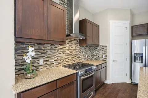 a kitchen with stainless steel appliances granite countertop a sink stove and refrigerator