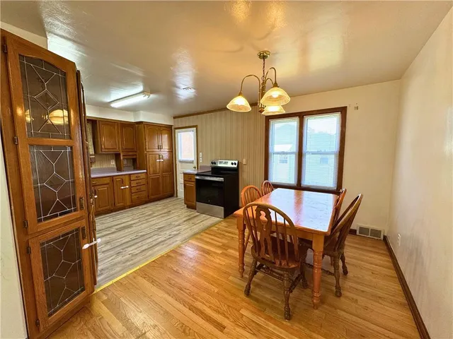 a view of a dining room with furniture a chandelier and wooden floor