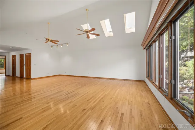 a view of empty room with wooden floor and fan