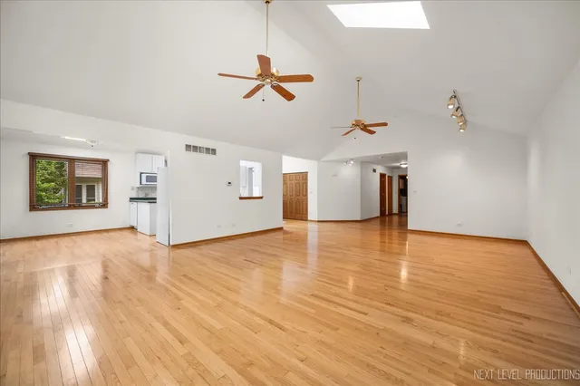 a view of a livingroom with wooden floor and a ceiling fan