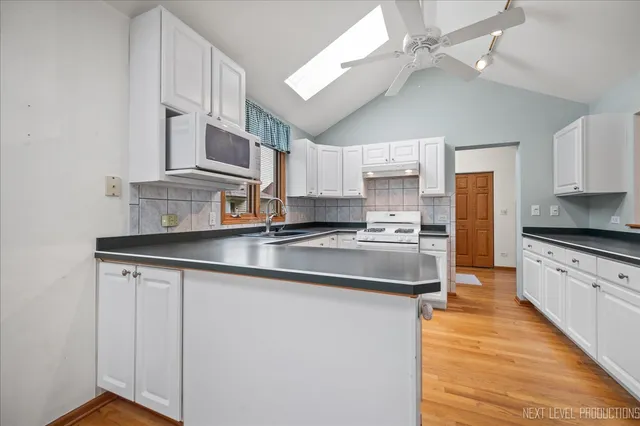a kitchen with stainless steel appliances granite countertop a sink a stove and cabinets