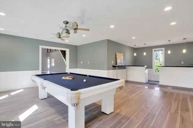 a kitchen with stainless steel appliances granite countertop a sink a stove and a wooden floors