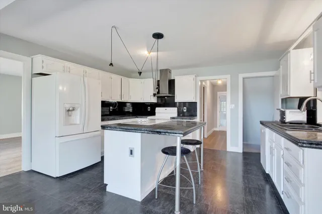a kitchen with stainless steel appliances granite countertop a sink a stove and a wooden floors
