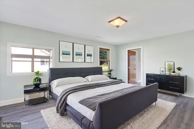 an empty room with wooden floor and a ceiling fan