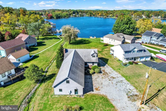 an aerial view of a house with a garden and lake view