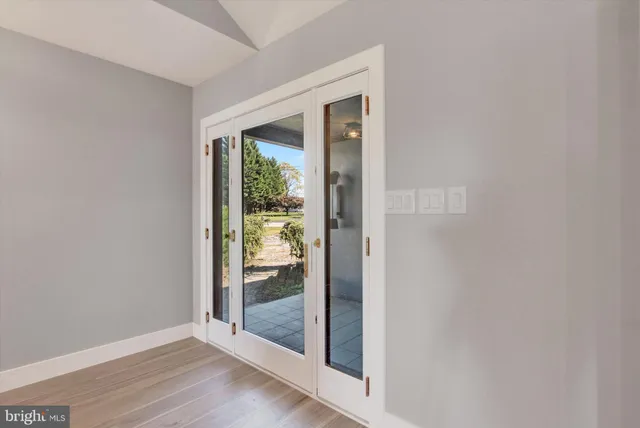 a view of a hallway with wooden floor and a livingroom
