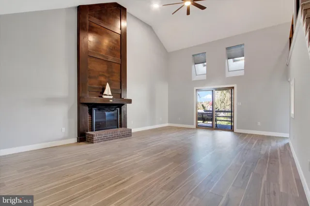 a view of an empty room with wooden floor and stairs