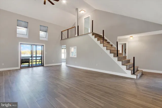 a view of a livingroom with wooden floor and stairs