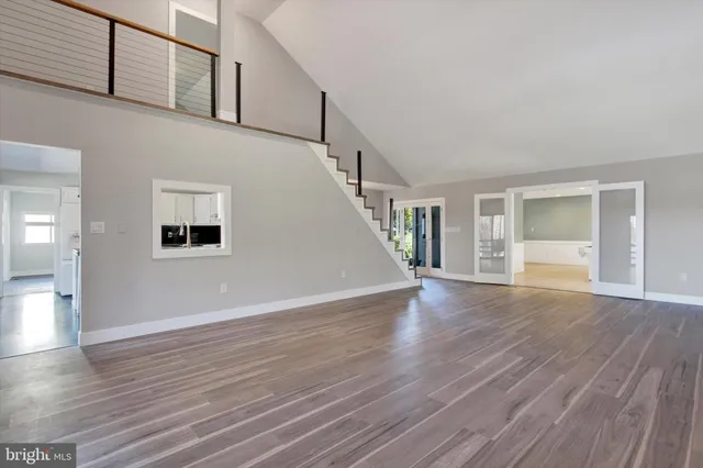 a room with wooden floor a table and chairs