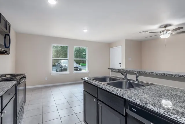 an empty room with a window and a fan