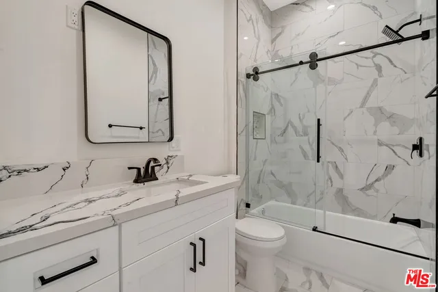 a bedroom with a bed and a lamp on dresser