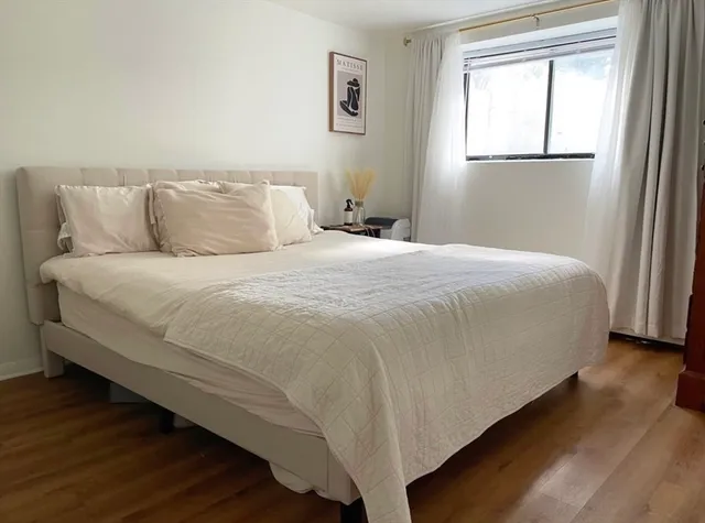 a large bed sitting in a bedroom next to a window