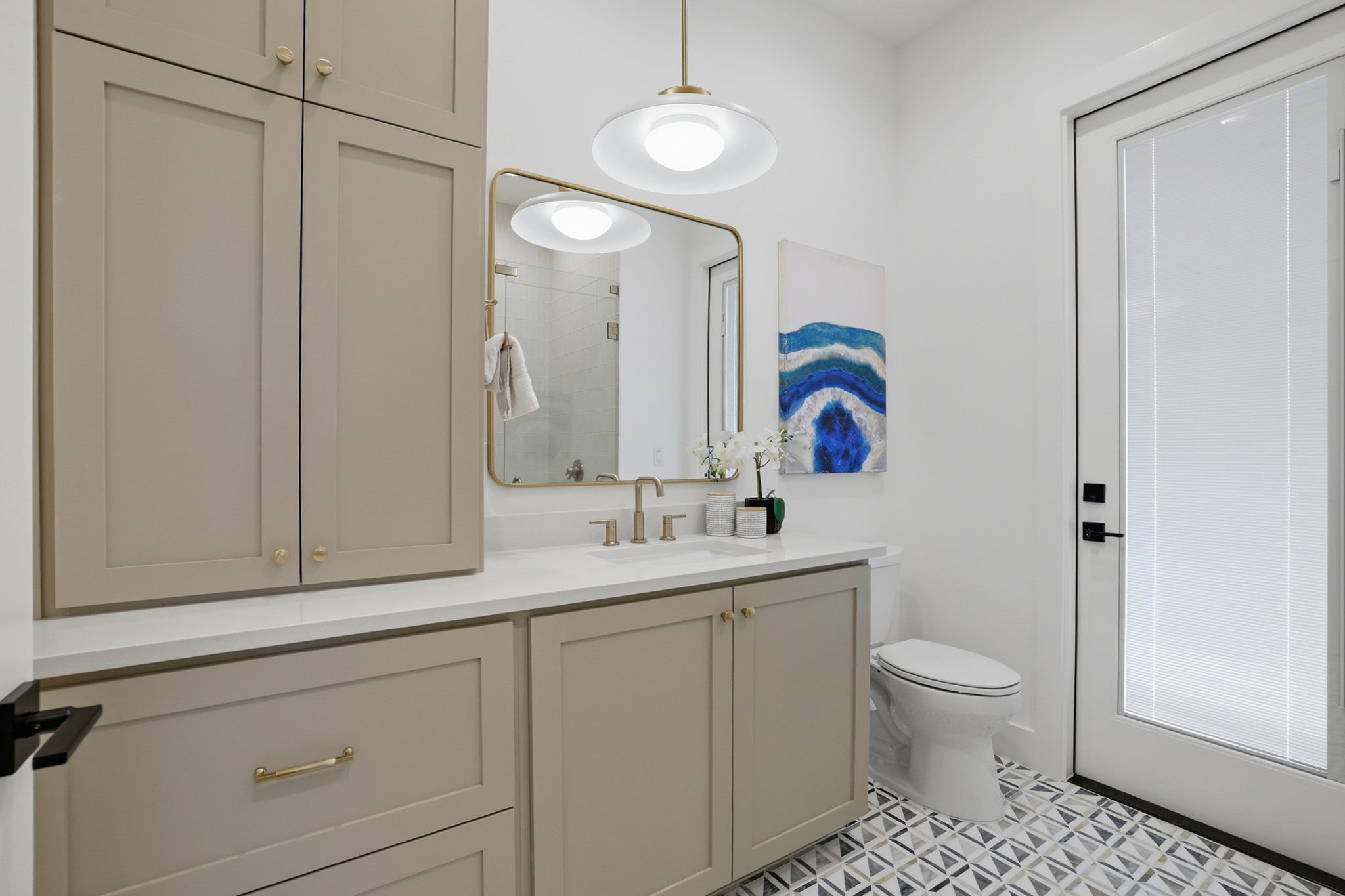 6611 Lexington Road Austin, TX 78757 - Photo 6 of 37 Bathroom vanity featuring extensive cabinetry with brass hardware, a white countertop, and an undermount sink