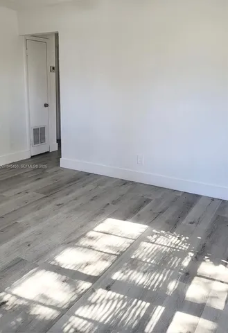 a view of a room with wooden floor and white walls