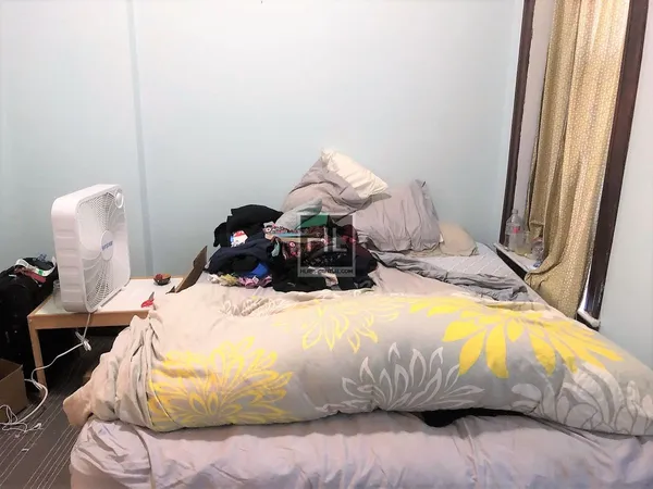 a bedroom with a bed and a window