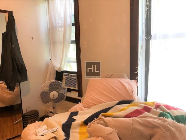 a bedroom with a bed and a window