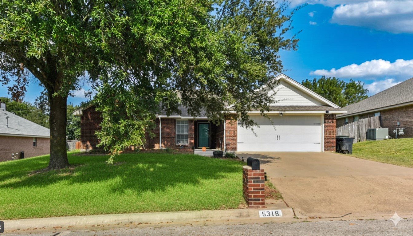 View of front facade featuring brick siding, a front lawn, concrete driveway, and an attached garage