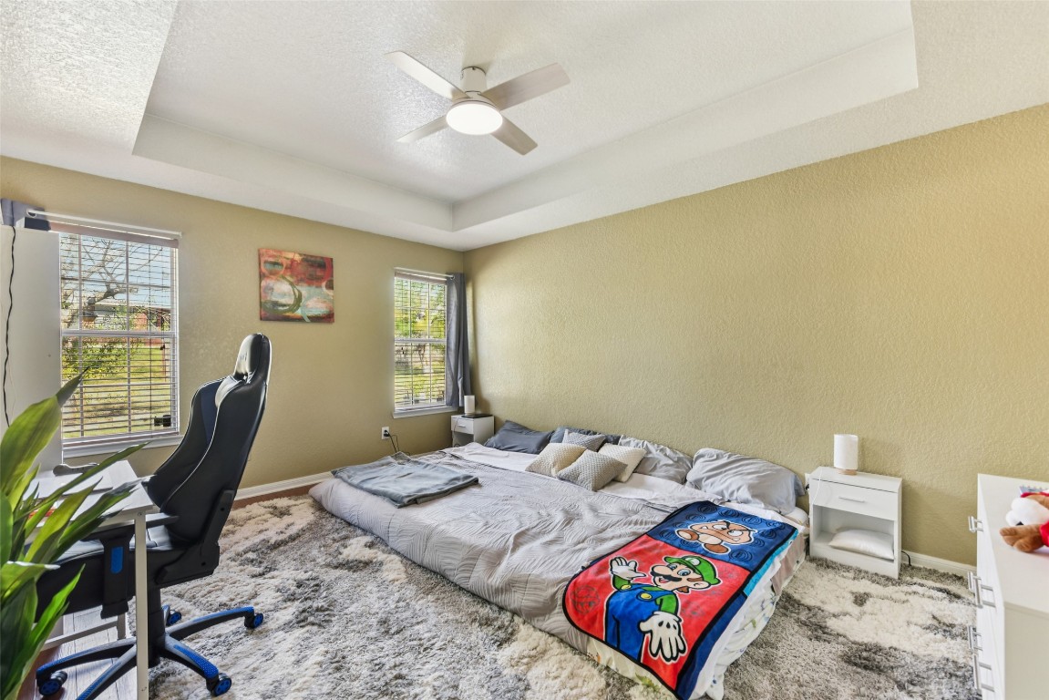 5318 West Ridge Boulevard Temple, TX 76502 - Photo 15 of 27 Bedroom featuring a raised ceiling, a textured wall, a ceiling fan, a textured ceiling, and a desk