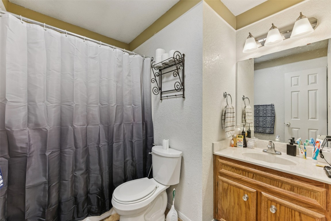 5318 West Ridge Boulevard Temple, TX 76502 - Photo 22 of 27 Full bathroom with vanity, a textured wall, and a shower with shower curtain