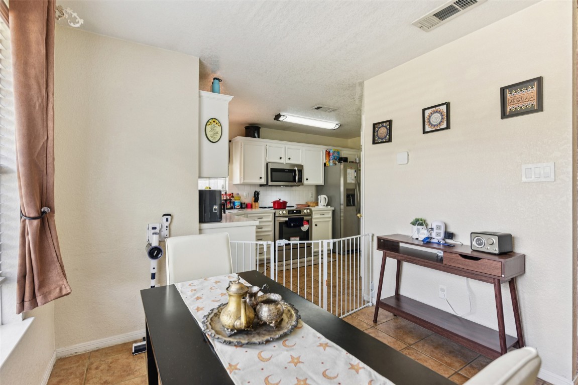 5318 West Ridge Boulevard Temple, TX 76502 - Photo 6 of 27 Dining area featuring light tile patterned flooring and a textured ceiling