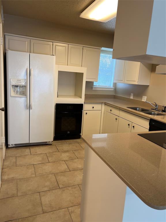 2234 Irwin Street Fort Worth, TX 76110 - Photo 3 of 17 a kitchen with cabinets and a refrigerator