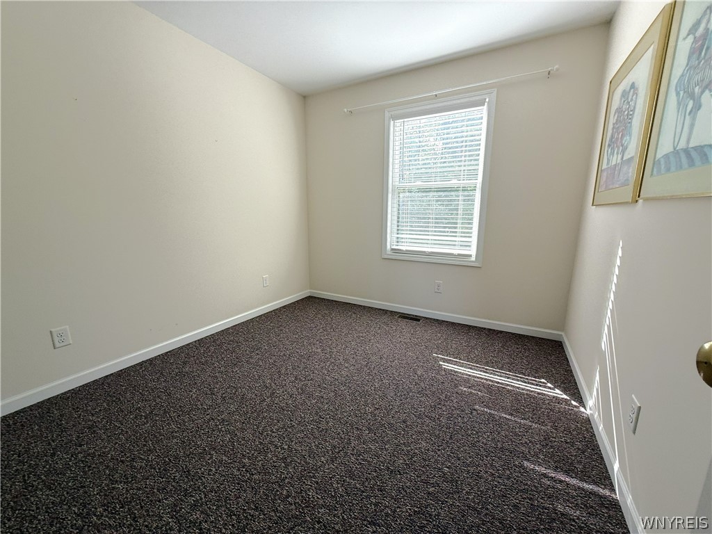 73 Chestnut Lancaster, NY 14086 - Photo 26 of 41 Plentiful natural light streams across the textured carpet of this quiet, neutral bedroom.