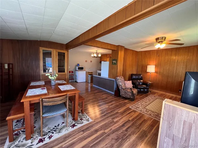 a living room with furniture a rug and paintings on the wall