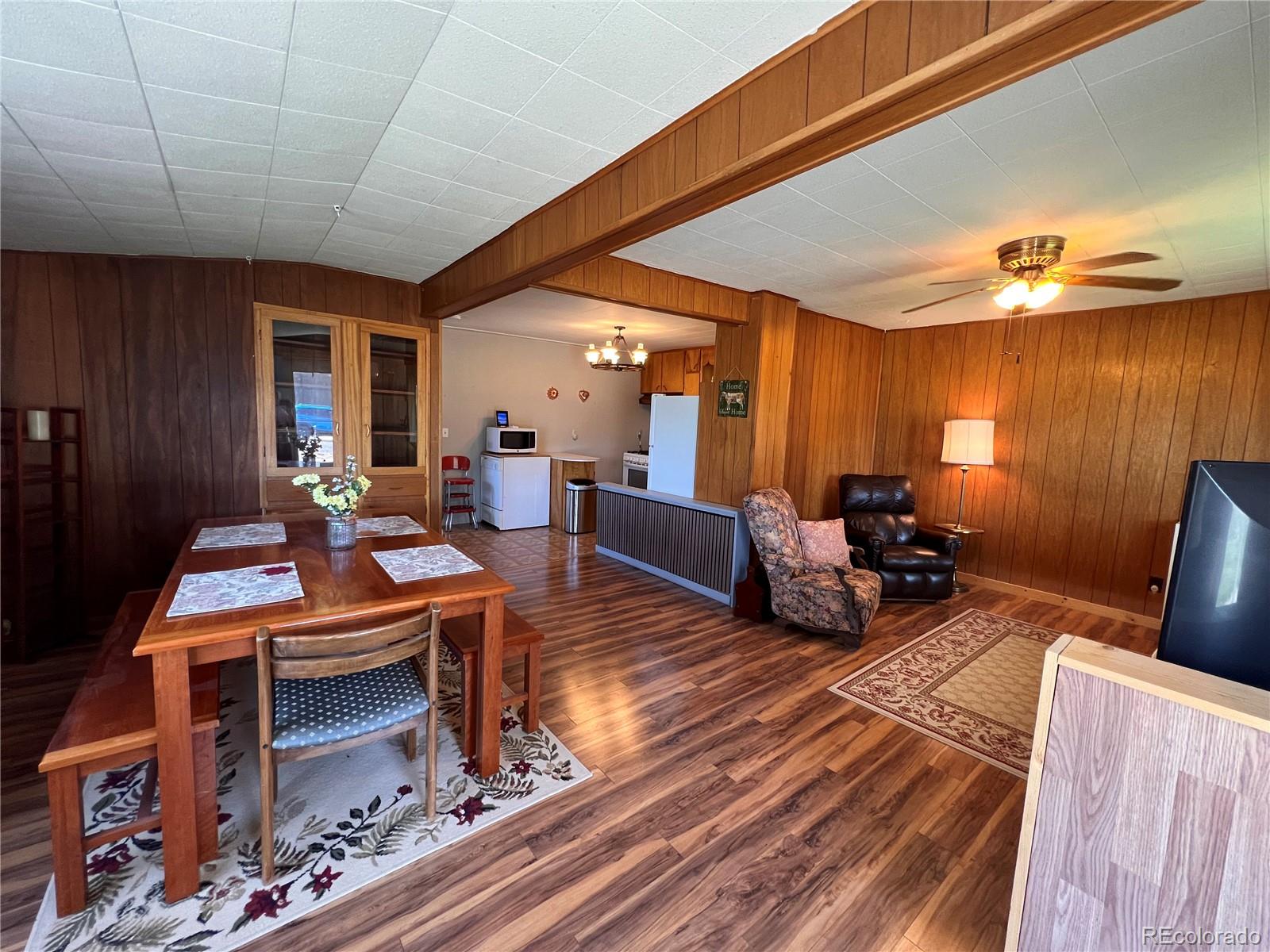 a living room with furniture a rug and paintings on the wall