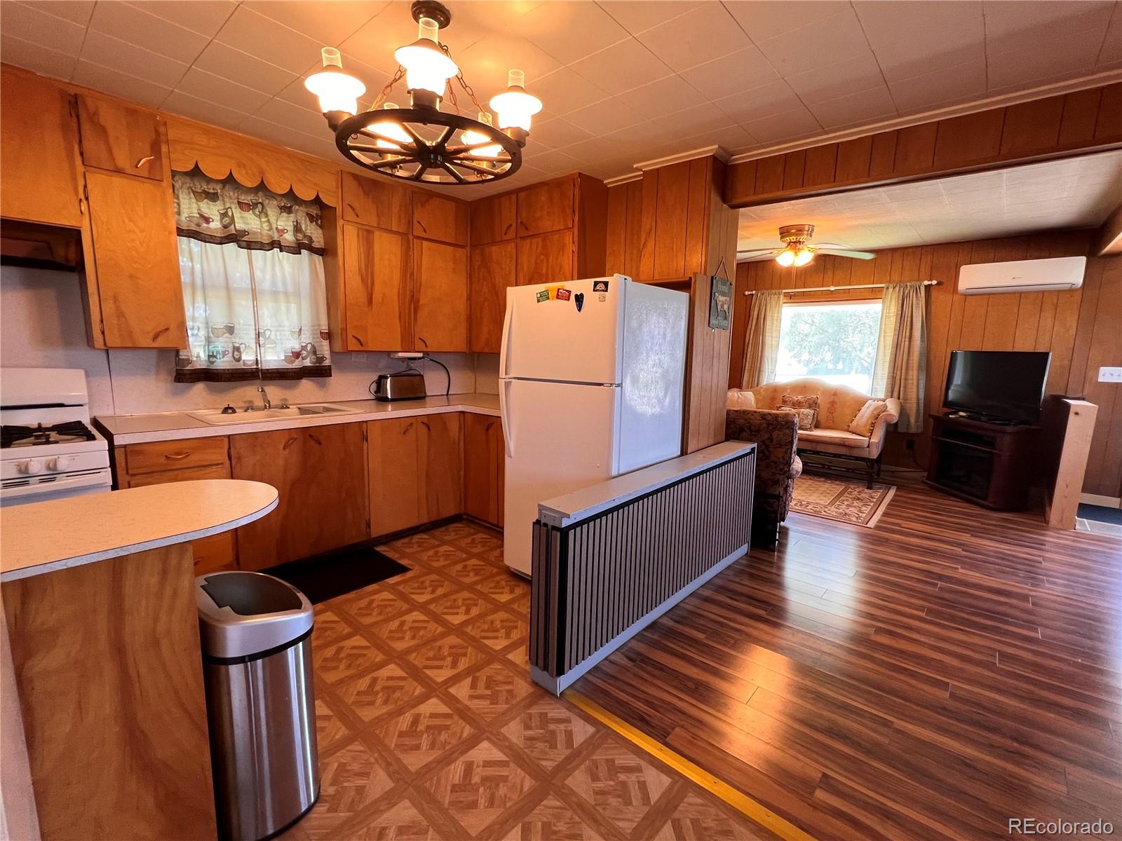 204 Main Street Genoa, CO 80818 - Photo 14 of 25 a kitchen with stainless steel appliances granite countertop a refrigerator a sink dishwasher a dining table and chairs with wooden floor